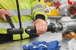 Technician using a proper fitting tool kit to apply even force to bearing rings, preventing raceway indentation during cold mounting.