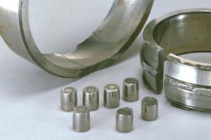 Damaged 22320EAE4 bearing showing fractured stamped steel cage and scattered rollers due to vibration fatigue.